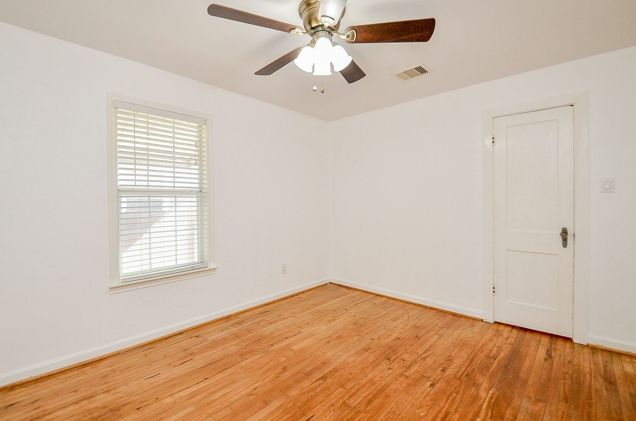 7707 Scanlock Street Houston, TX 77012 - Photo 13 of 19 an empty room with a window and a fan
