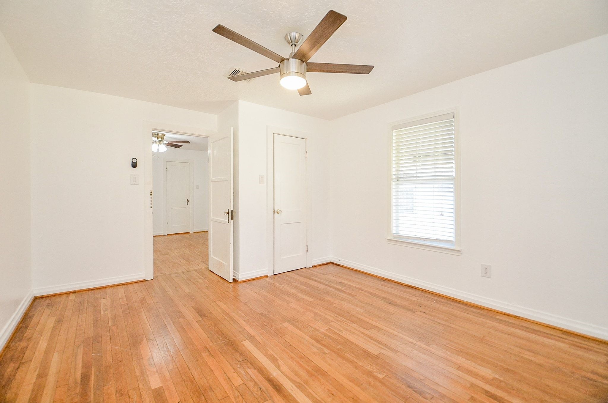 7707 Scanlock Street Houston, TX 77012 - Photo 14 of 19 an empty room with wooden floor and a ceiling fan