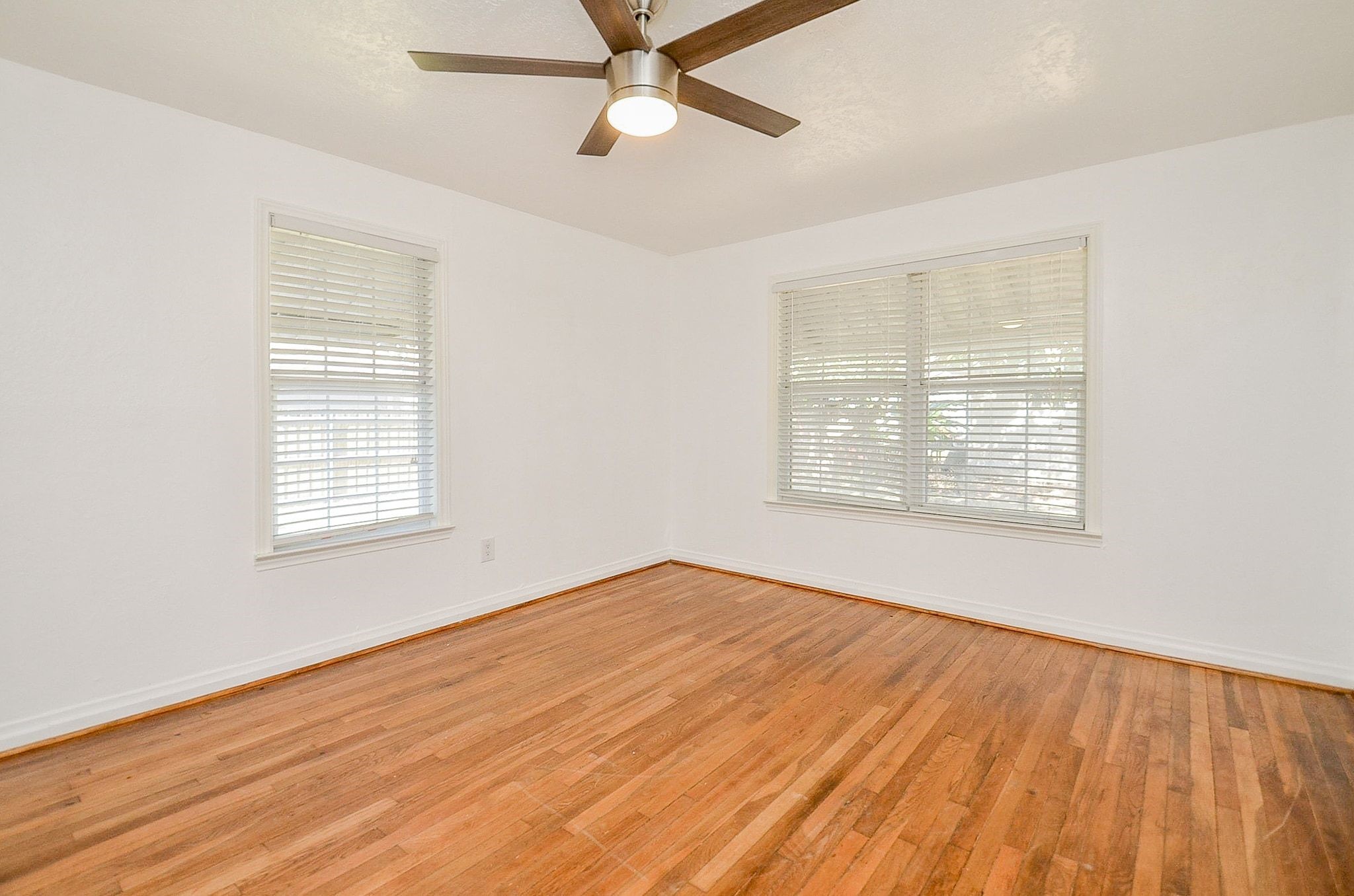7707 Scanlock Street Houston, TX 77012 - Photo 15 of 19 a view of an empty room with wooden floor and a window
