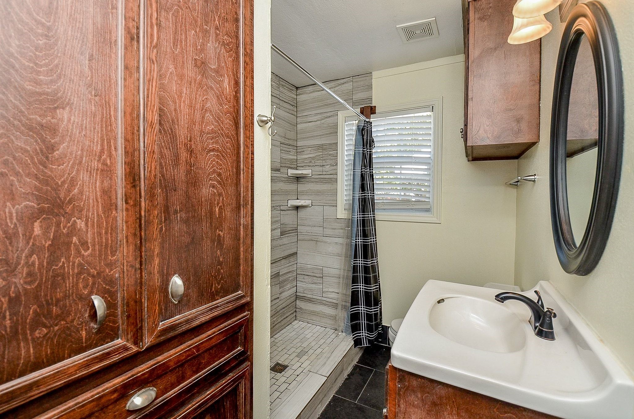 7707 Scanlock Street Houston, TX 77012 - Photo 4 of 19 a bathroom with a sink and mirror with bathtub