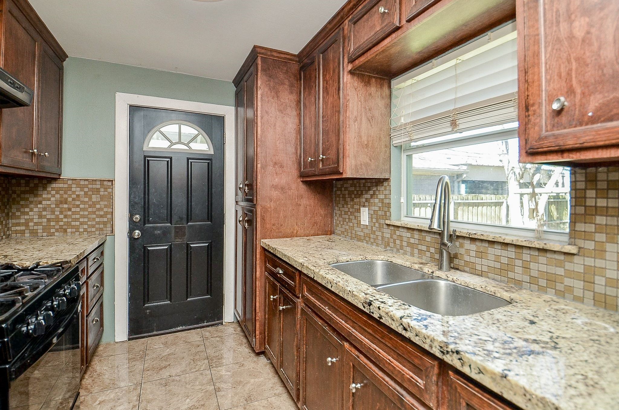 7707 Scanlock Street Houston, TX 77012 - Photo 8 of 19 a kitchen with granite countertop a sink stainless steel appliances a counter space and cabinets