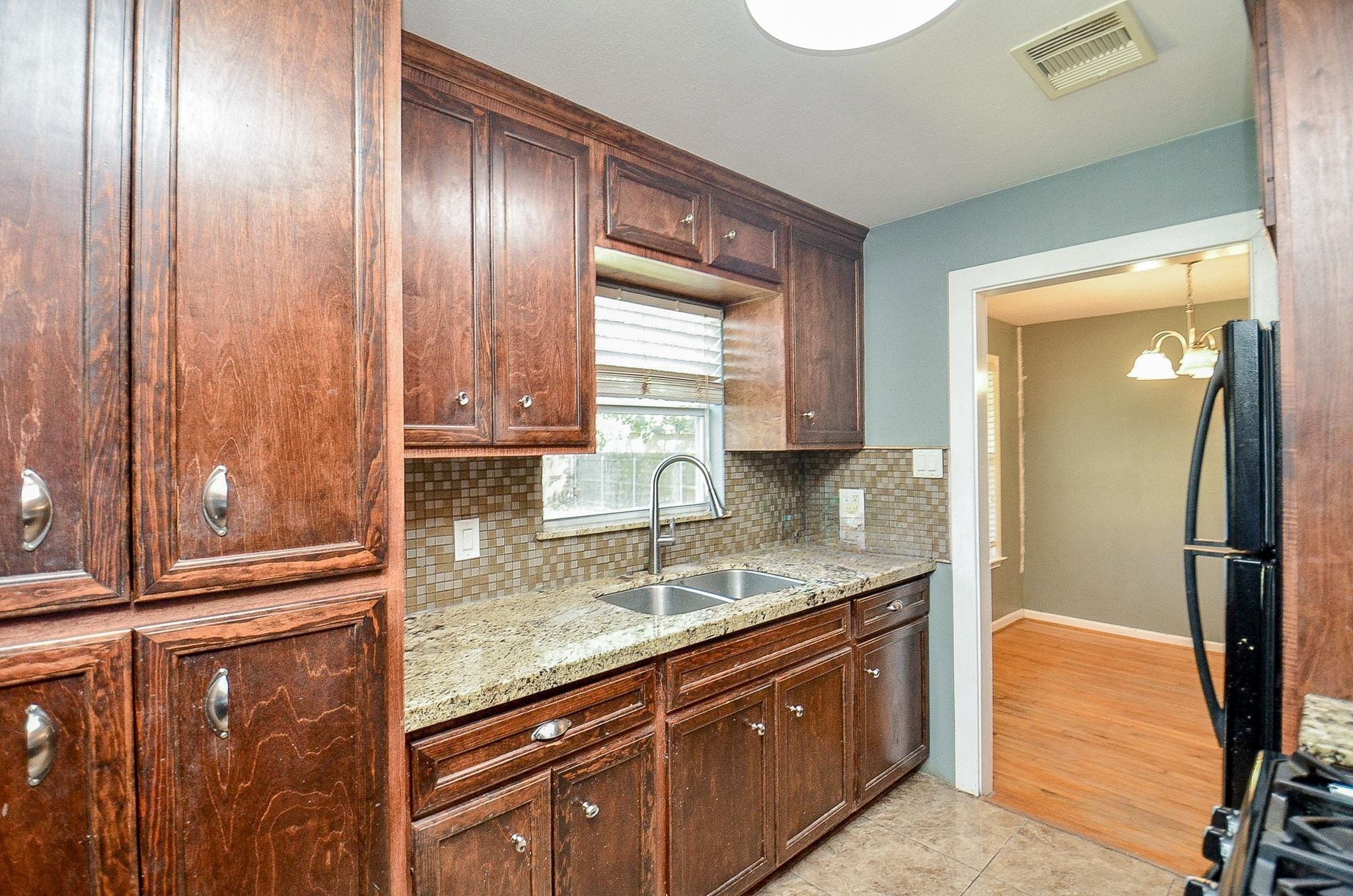 7707 Scanlock Street Houston, TX 77012 - Photo 9 of 19 a kitchen with granite countertop stainless steel appliances and wooden cabinets