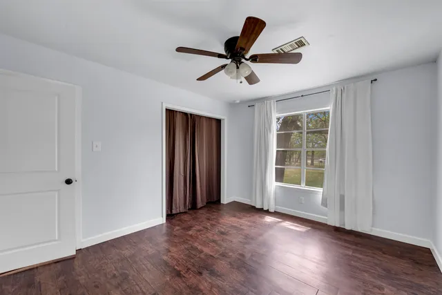 a view of a livingroom with a ceiling fan & hardwood floor