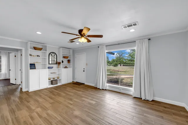 a view of a bedroom with wooden floor and a window