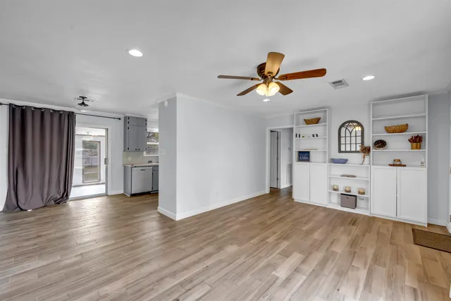 a view of a kitchen with a sink and a refrigerator a microwave oven a refrigerator with wooden floor