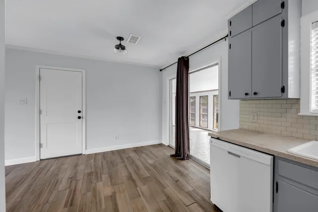 a kitchen with a sink window and wooden floor