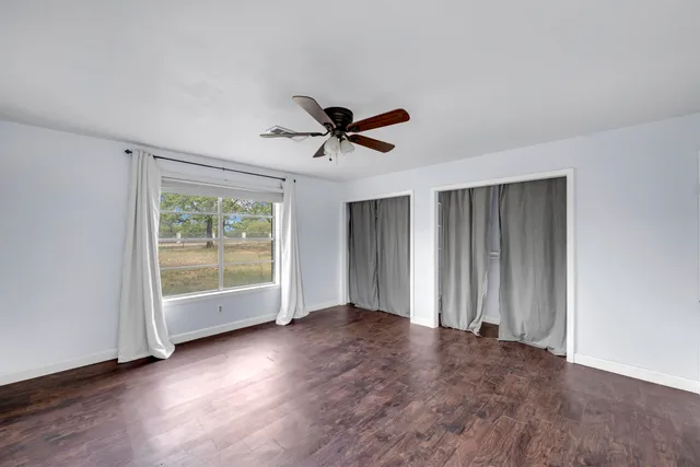 an empty room with fan and windows