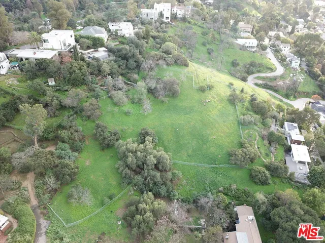 an aerial view of residential house with outdoor space and trees all around