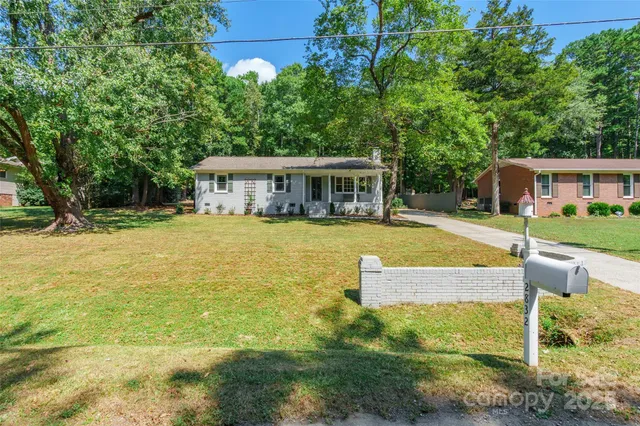 a view of swimming pool with lawn chairs and plants