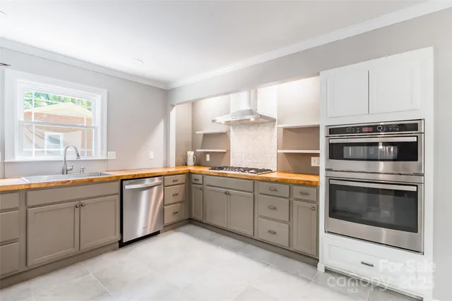 a kitchen with stainless steel appliances granite countertop a sink and cabinets with wooden floor