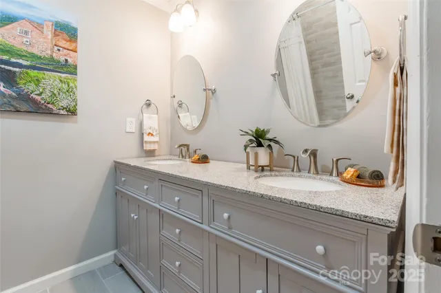 a bathroom with a granite countertop double vanity sink and a mirror