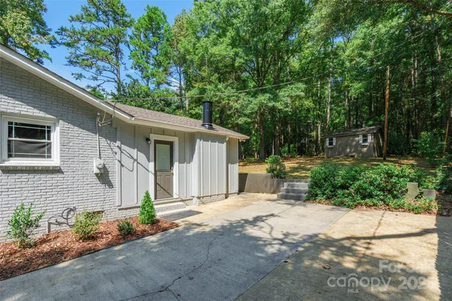 a view of a house with backyard and sitting area