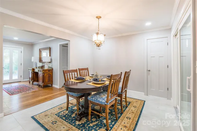 a dining room with furniture a chandelier and wooden floor