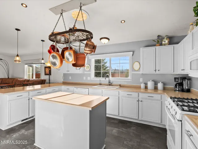 a kitchen with granite countertop a sink stove and cabinets