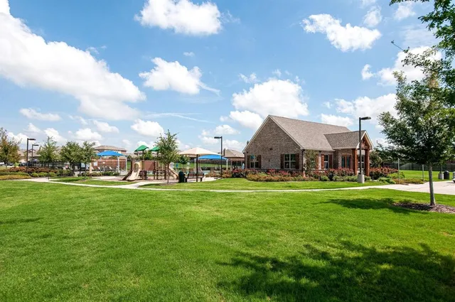 a front view of a house with a big yard and a fountain
