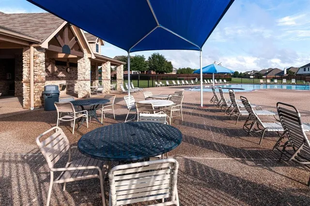 a view of a patio with table and chairs under an umbrella