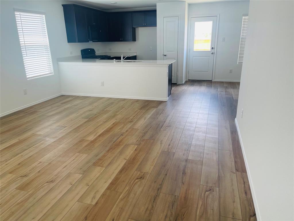 324 Red Rock Trail Haslet, TX 76052 - Photo 2 of 15 an empty room with wooden floor and windows