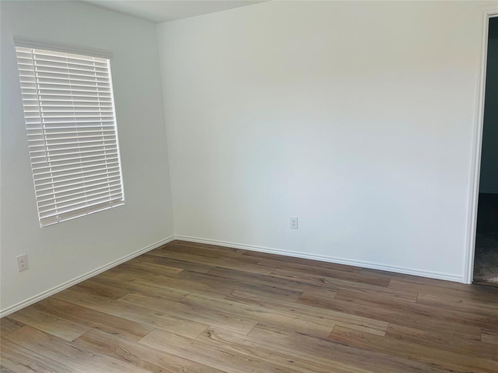 324 Red Rock Trail Haslet, TX 76052 - Photo 5 of 15 a view of an empty room with wooden floor and a window