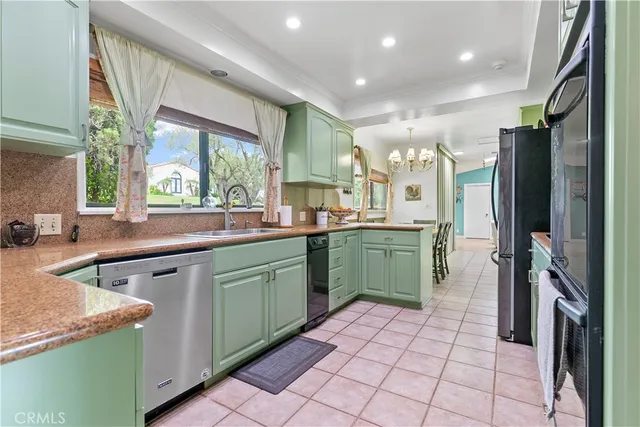 a kitchen with a sink a counter top space stainless steel appliances and a large window