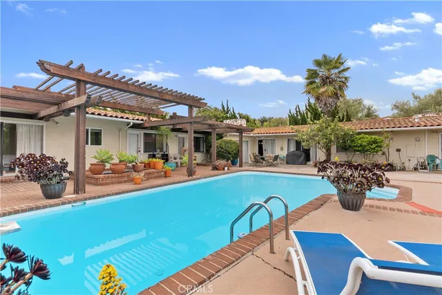 a view of a house with swimming pool and sitting area