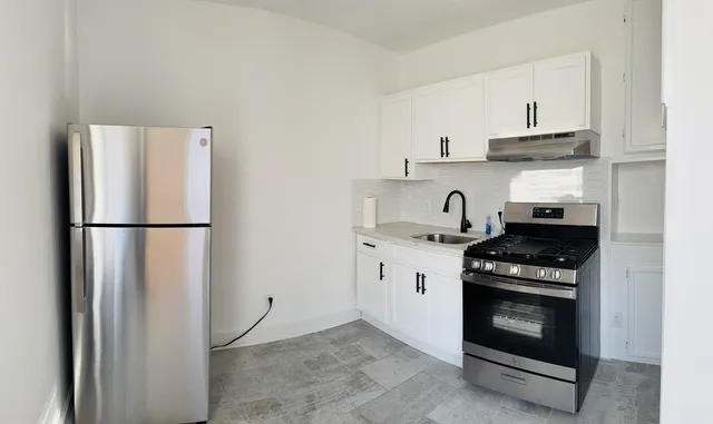 a kitchen with stainless steel appliances granite countertop a stove a refrigerator and a sink