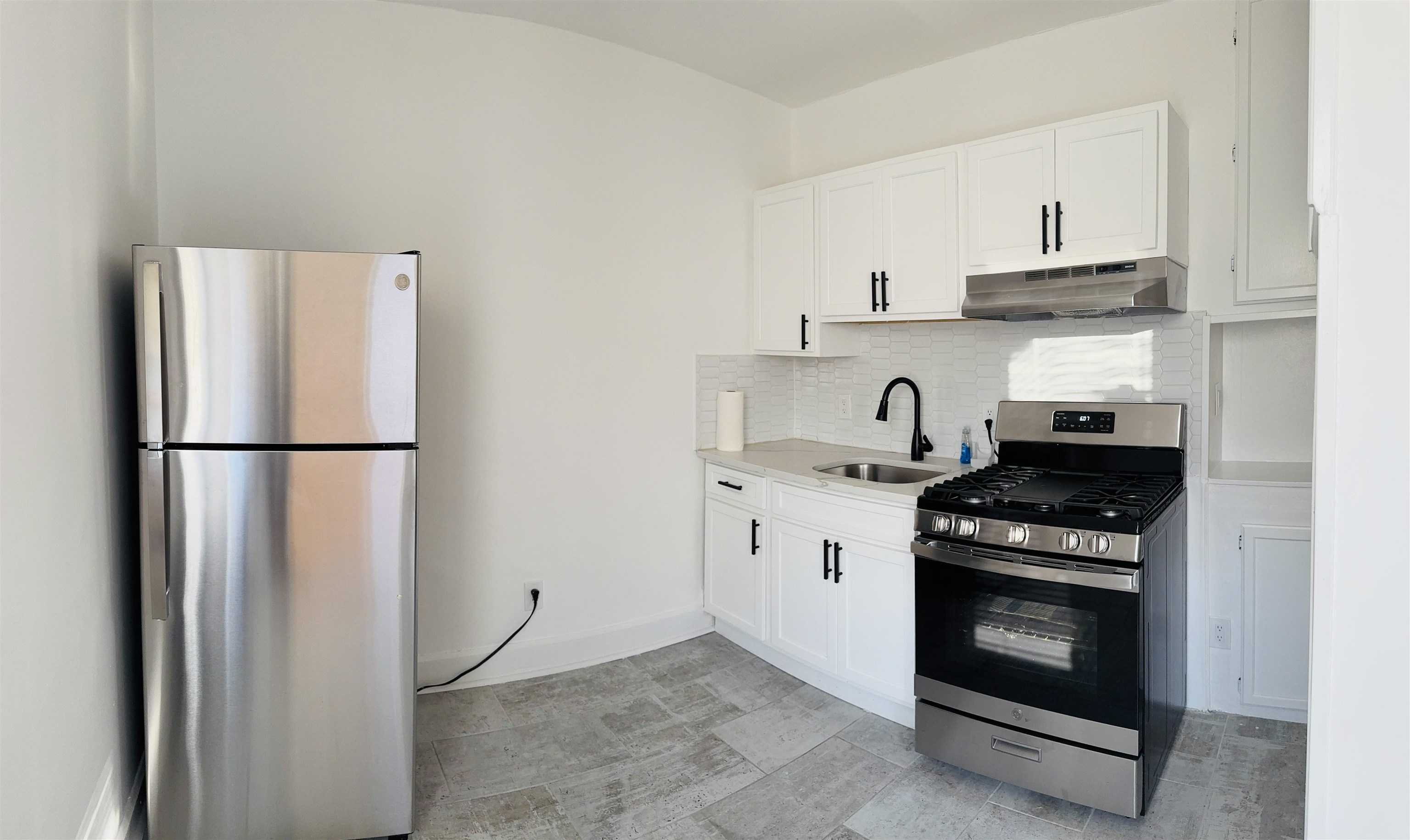 a kitchen with stainless steel appliances granite countertop a stove a refrigerator and a sink