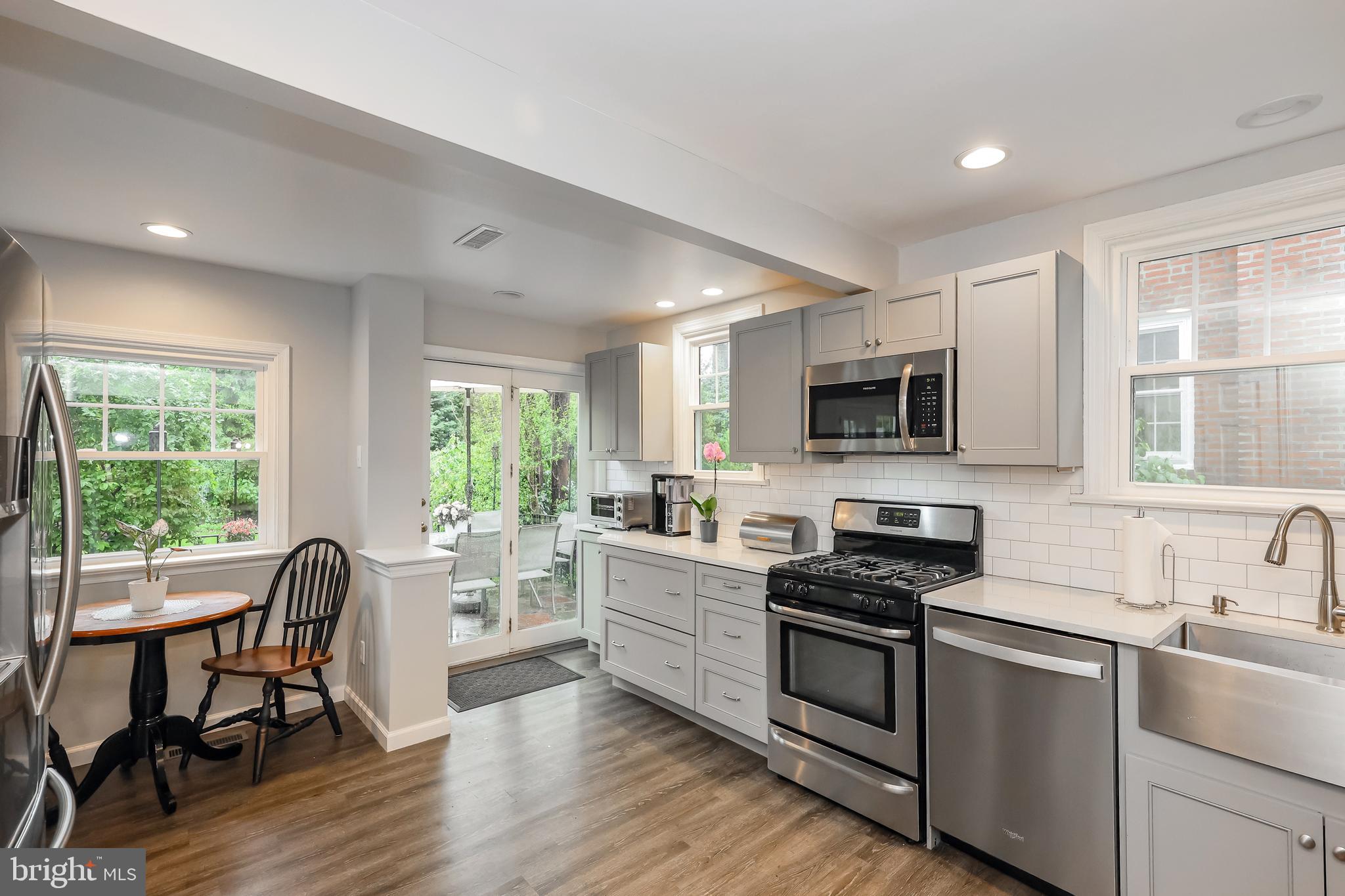 2710 Prescott Road Havertown, PA 19083 - Photo 13 of 38 a kitchen with stainless steel appliances a stove top oven a sink dishwasher a dining table and chairs with wooden floor