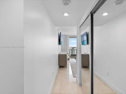 a view of a hallway with furniture and a bathroom