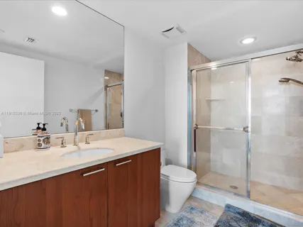 a bathroom with a sink shower and a mirror