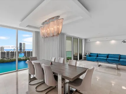 a kitchen with stainless steel appliances granite countertop a kitchen island a stove a sink a refrigerator and chairs