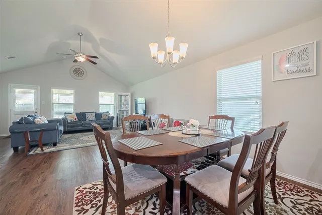 a view of a dining room with furniture a chandelier and wooden floor