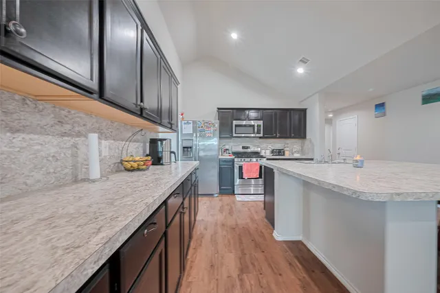 a kitchen with stainless steel appliances granite countertop a sink a stove and cabinets