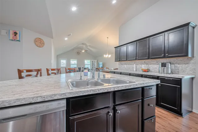 a kitchen with stainless steel appliances granite countertop a sink stove and cabinets