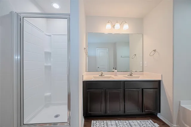 a bathroom with a tub a sink and mirror