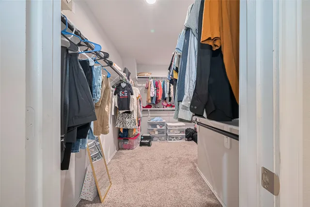 a view of walk in closet with clothes and shoes