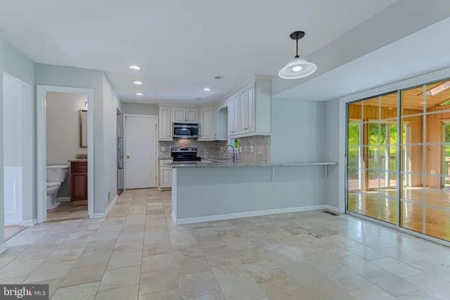 a view of kitchen with refrigerator and window
