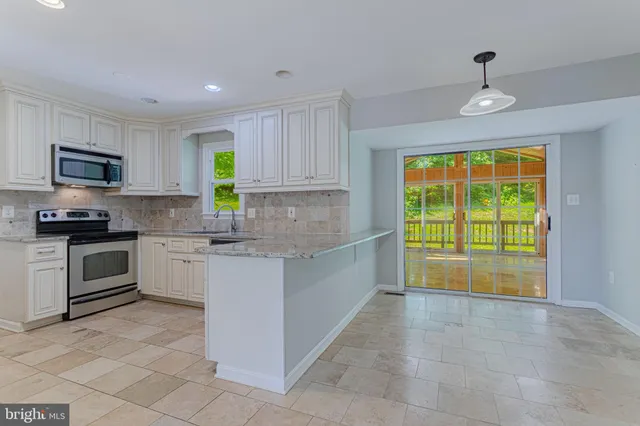 a kitchen with a stove a sink and a microwave