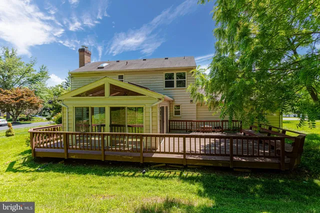 a view of a house with a yard and deck wooden floor