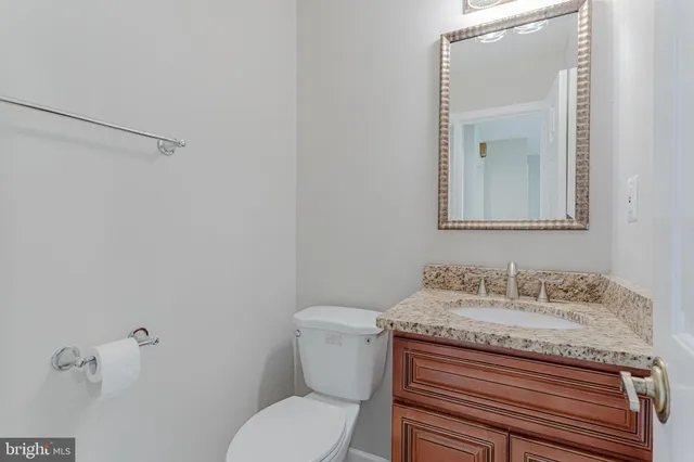 a bathroom with a granite countertop sink mirror and toilet