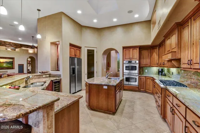 a kitchen with stainless steel appliances granite countertop sink stove and cabinets