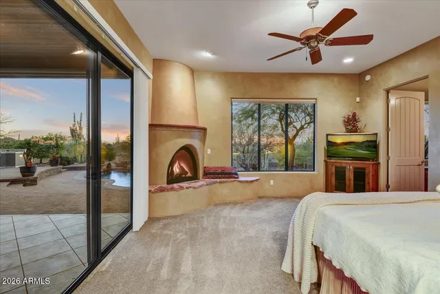 a bedroom with a bed a fireplace and a large window