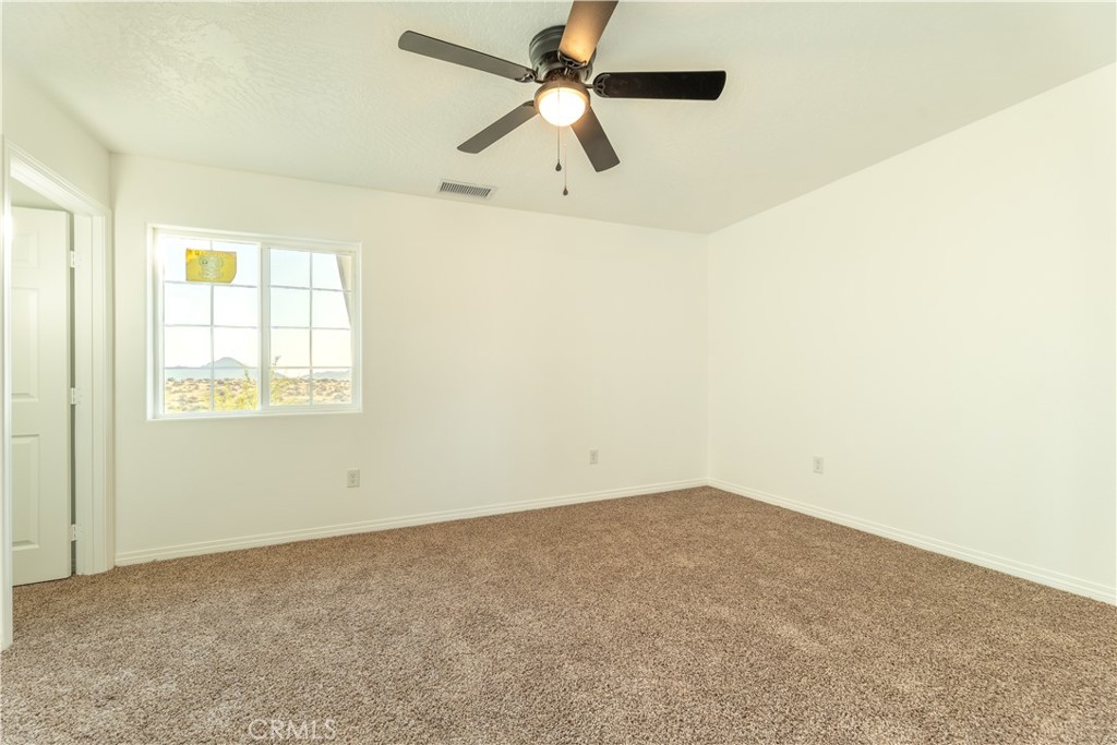16925 Nanticoke Road Apple Valley, CA 92307 - Photo 61 of 87 an empty room with a window and a ceiling fan