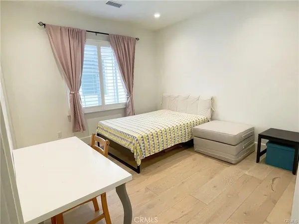 a bedroom with a bed wooden floor and window