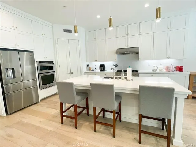a kitchen with kitchen island a sink stove and refrigerator