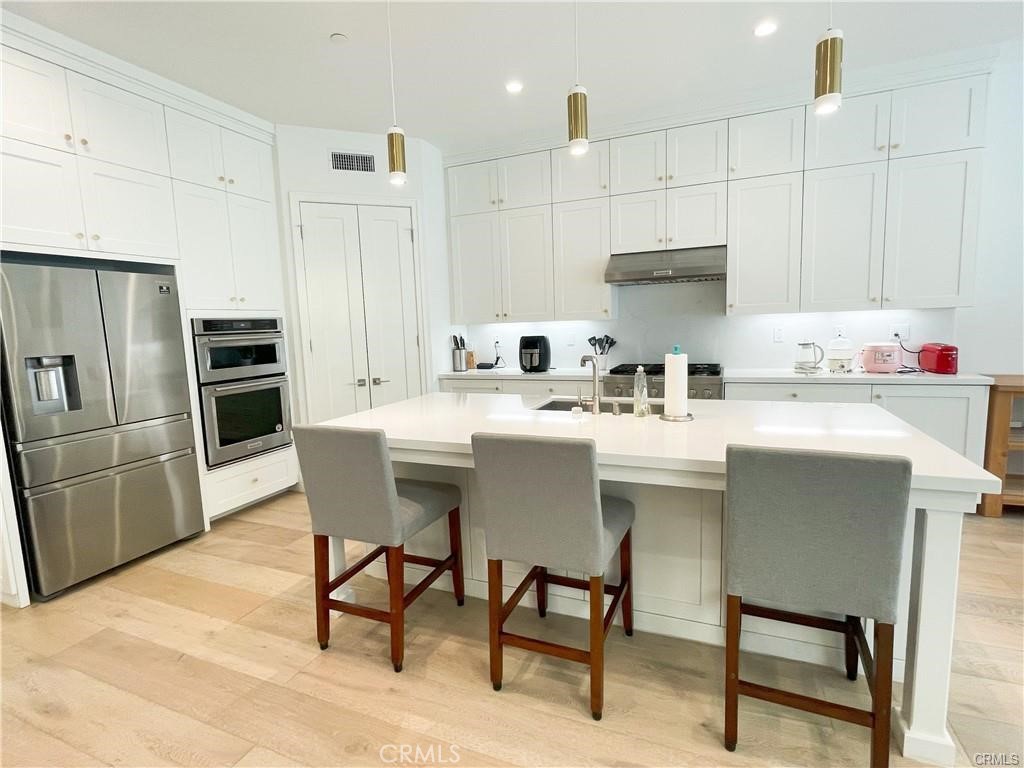 120 Statura Irvine, CA 92602 - Photo 6 of 27 a kitchen with kitchen island a sink stove and refrigerator