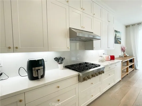 a kitchen with white cabinets and appliances