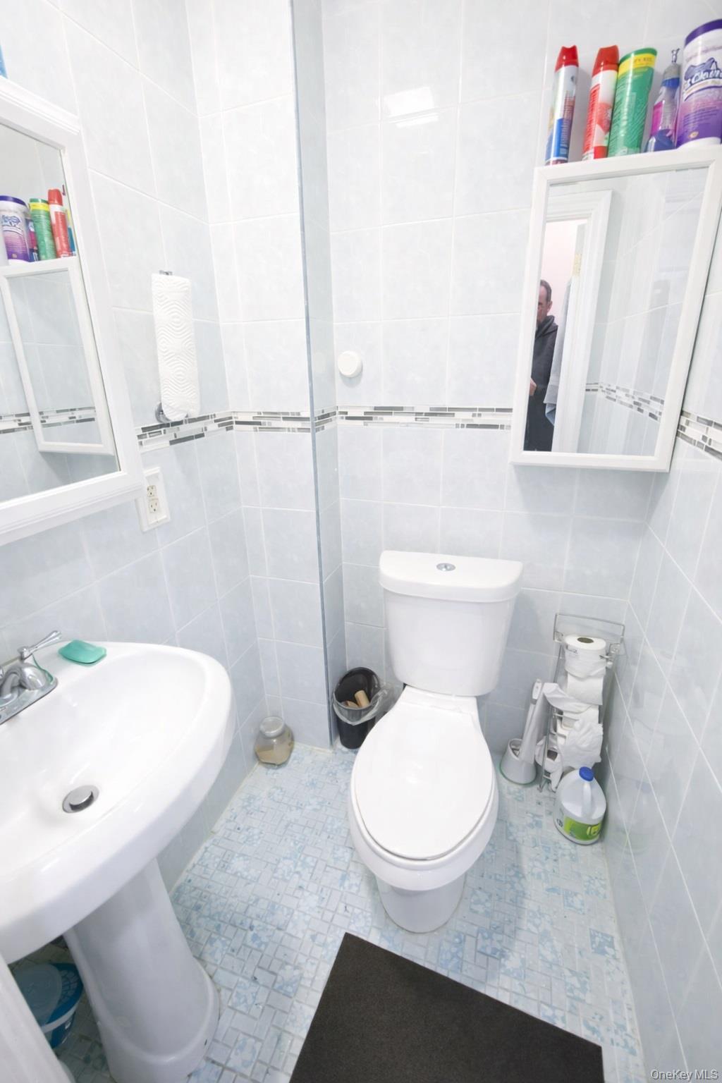 179-15 Selover Road Queens, NY 11434 - Photo 12 of 16 a white toilet sitting next to a bathroom sink and vanity