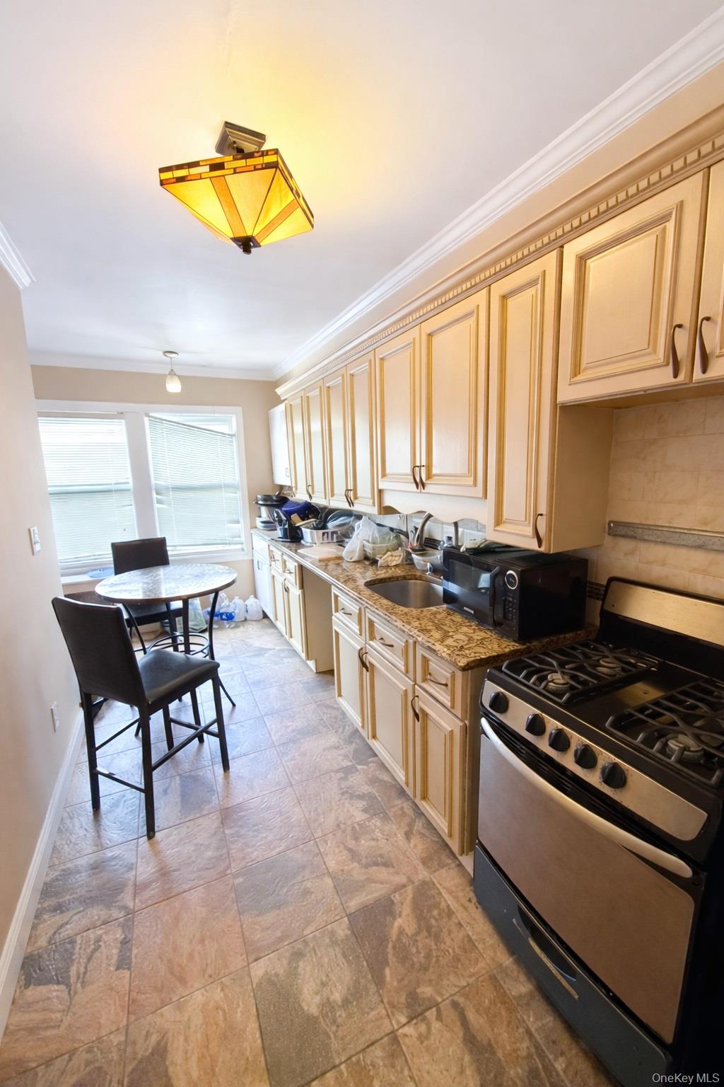 179-15 Selover Road Queens, NY 11434 - Photo 2 of 16 a kitchen with stainless steel appliances granite countertop a stove top oven a sink a dining table and chairs with the wooden floor