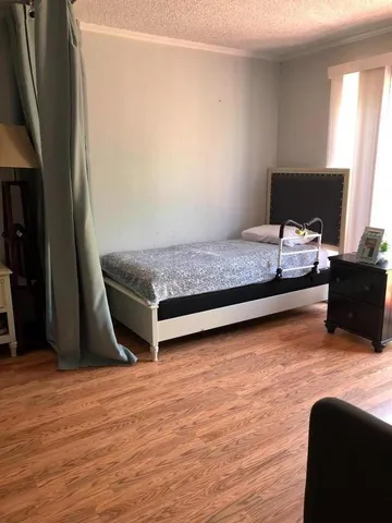 a bedroom with a bed table and chair