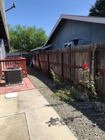 a view of backyard with table and chairs and wooden fence
